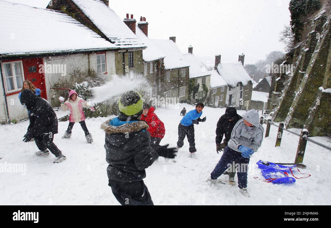 2009: Foto del archivo fechada el 2009 de febrero de los niños de la escuela que tienen una lucha de bola de nieve en el icónico Gold Hill en Shaftesbury, Dorset, donde había nevado todos los días esa semana. Fecha de emisión: Domingo 30 de enero de 2022. Foto de stock