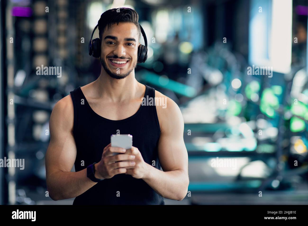 Hombre árabe joven deportivo con auriculares inalámbricos con