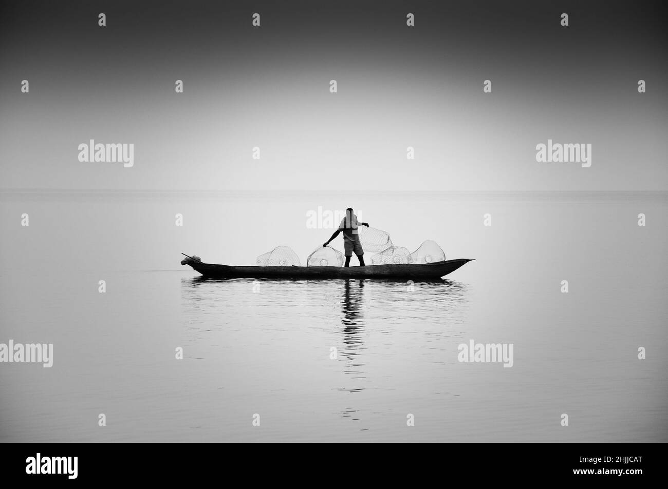 El lago Kivu, en la República Democrática del Congo. Un pescador solitario se prepara para los días de captura. Foto de stock