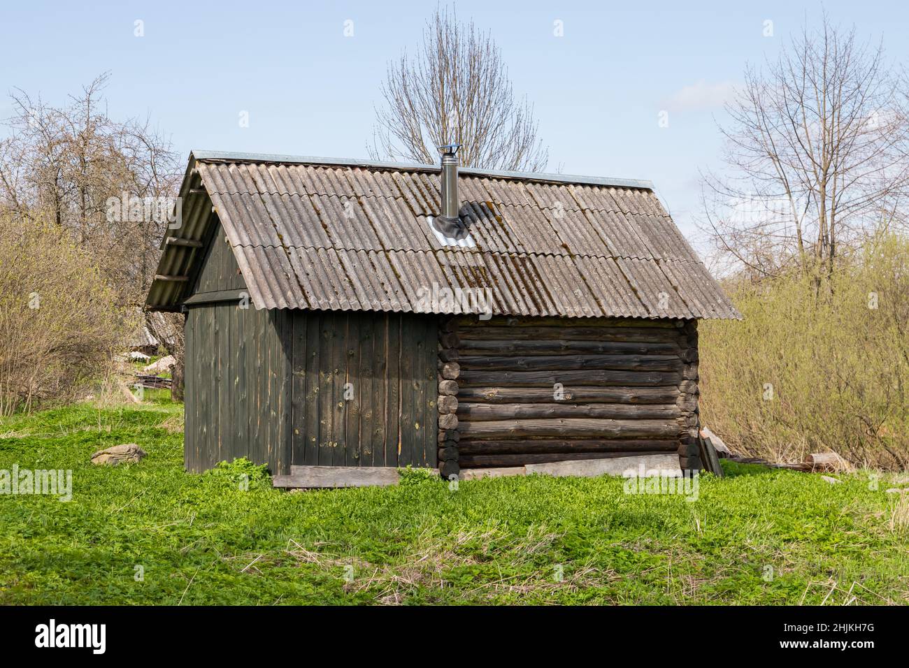 Ejemplo de arquitectura clásica de madera, pequeño edificio rural ruso sauna exterior durante el día Foto de stock