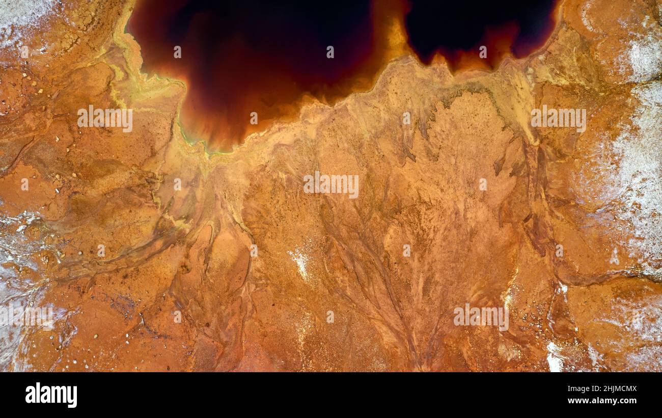 La orilla del lago rojo tóxico en el pozo abierto de la mina de cobre abandonada. Textura de la superficie de minería, vista aérea Foto de stock