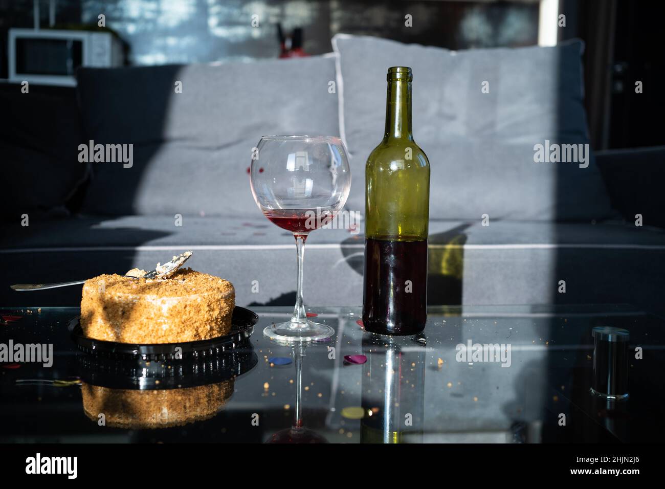 cumpleaños en casa, pastel y copa de vino tinto, alcohol para el día de san  valentín, botella de vino en la mesa junto al postre, celebración del día  de san valentín Fotografía