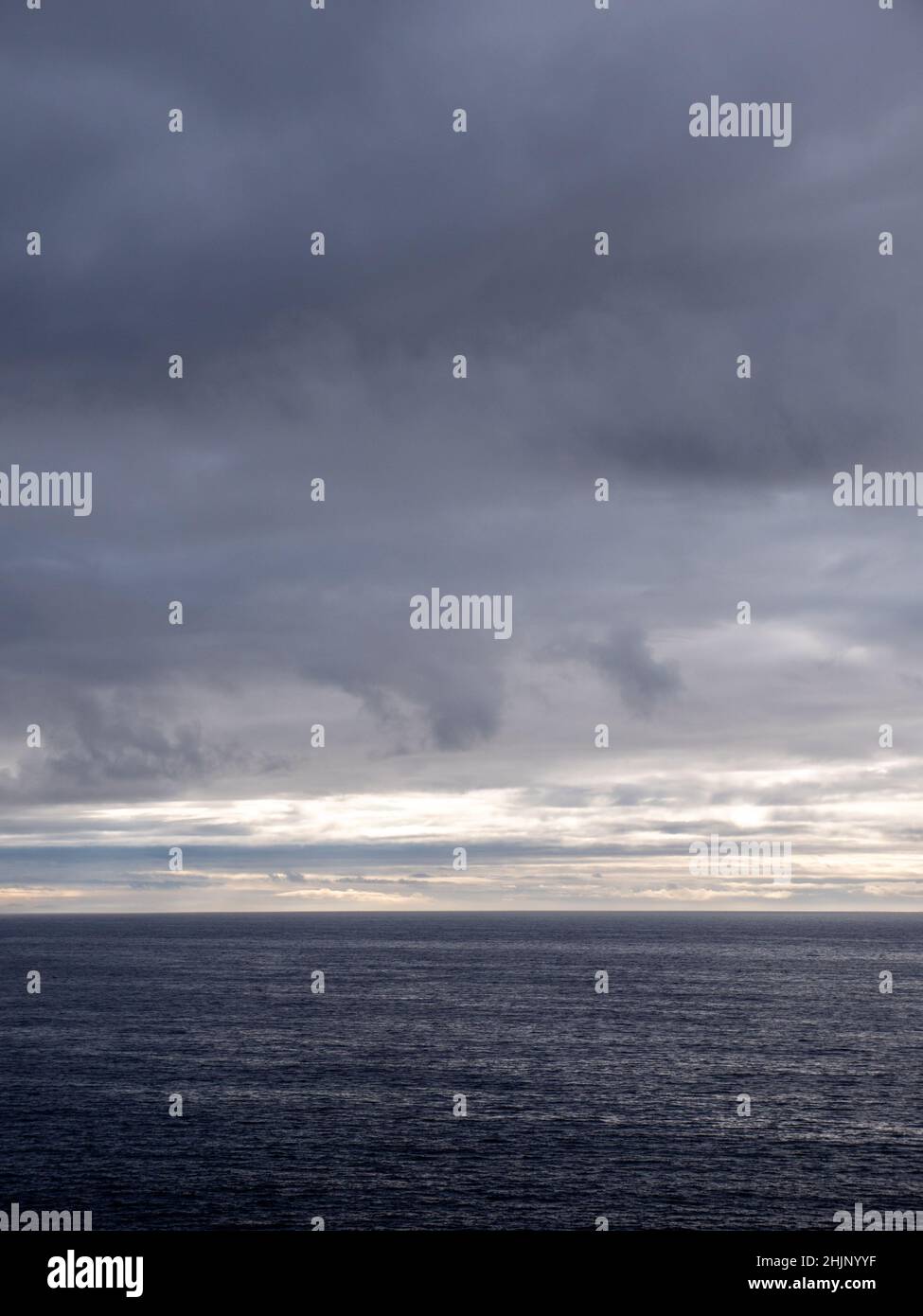 Un paisaje marino y vistas al mar a través del vacío Océano Atlántico desde la costa norte de Cornwall, Reino Unido, en un día gris nublado Foto de stock