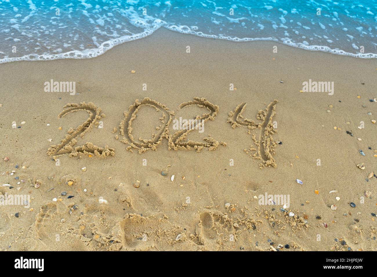 Los números 2024 están escritos en una playa de arena a orillas del mar