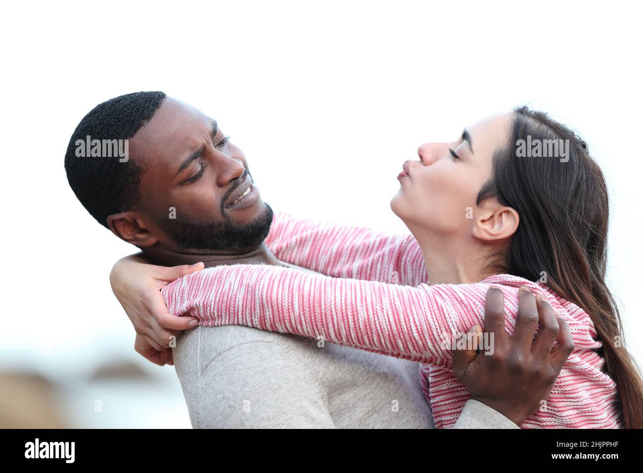 Vista lateral retrato de una mujer tratando de besar a un hombre que la aleja Foto de stock
