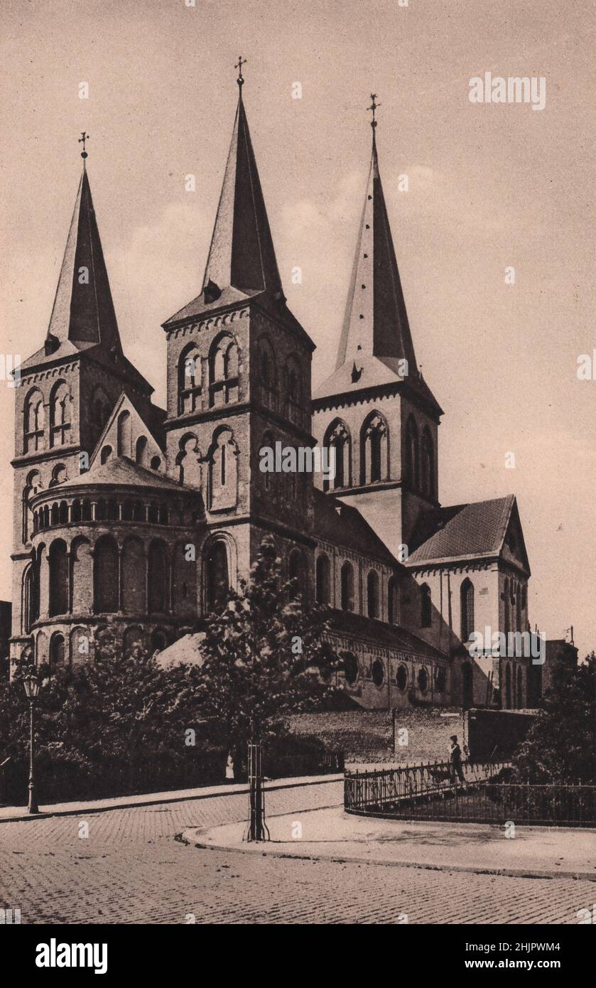 Cerca del Rin y el extremo norte de la ciudad se levantan las tres agujas y el techo abovedado de S. Cunibert, Consagrado en 1248. Alemania. Colonia (1923) Foto de stock