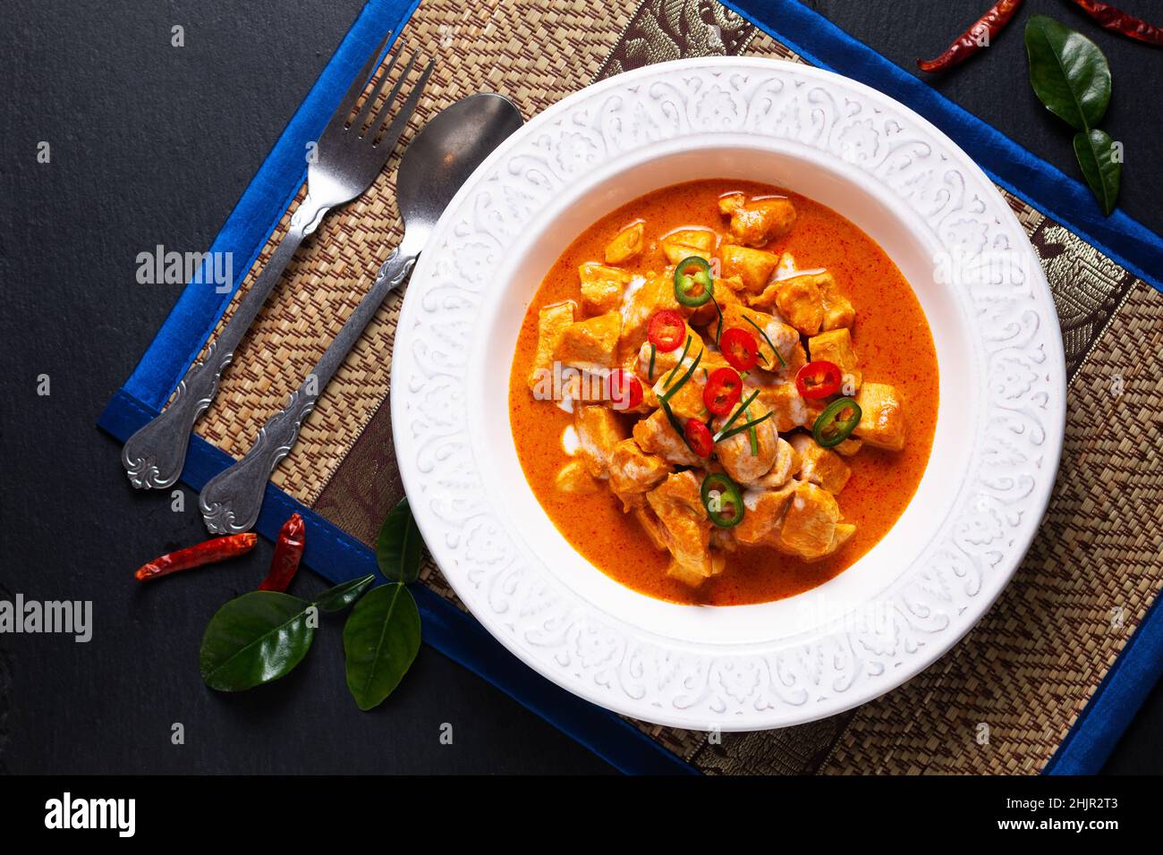 Concepto de comida tailandesa Auténtico pollo tailandés Panang Curry, Panang Kai en un tazón de cerámica sobre fondo negro con espacio de copia Foto de stock