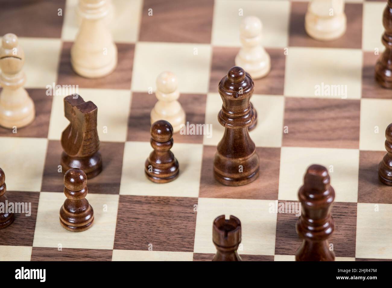 Tablero de ajedrez con Reina en foco, rodeado de peones, caballero y obispo Foto de stock