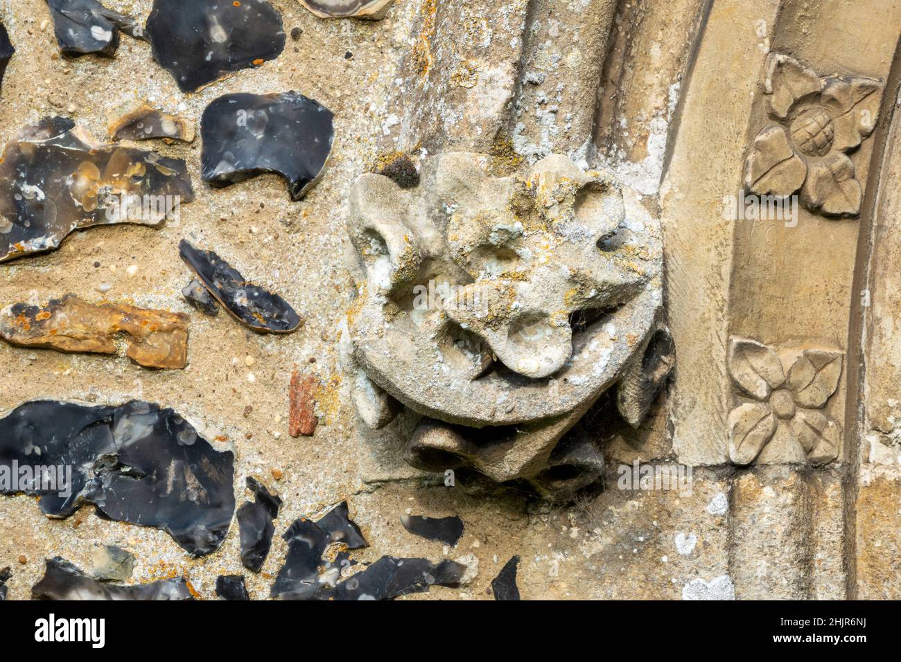 Corbel de piedra tallada al final del molde de la capucha en una puerta de la Iglesia de San Lorenzo, Brundish, Suffolk, Reino Unido Foto de stock