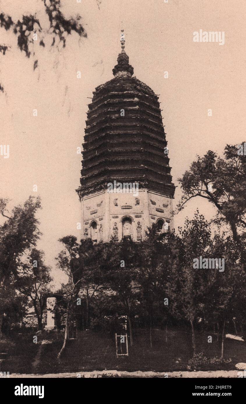 Imágenes talladas de Buda miran sobre el jardín desde nichos en los lados de la Pai-ta o Torre Blanca de Liao-yang. China. Manchuria (1923) Foto de stock