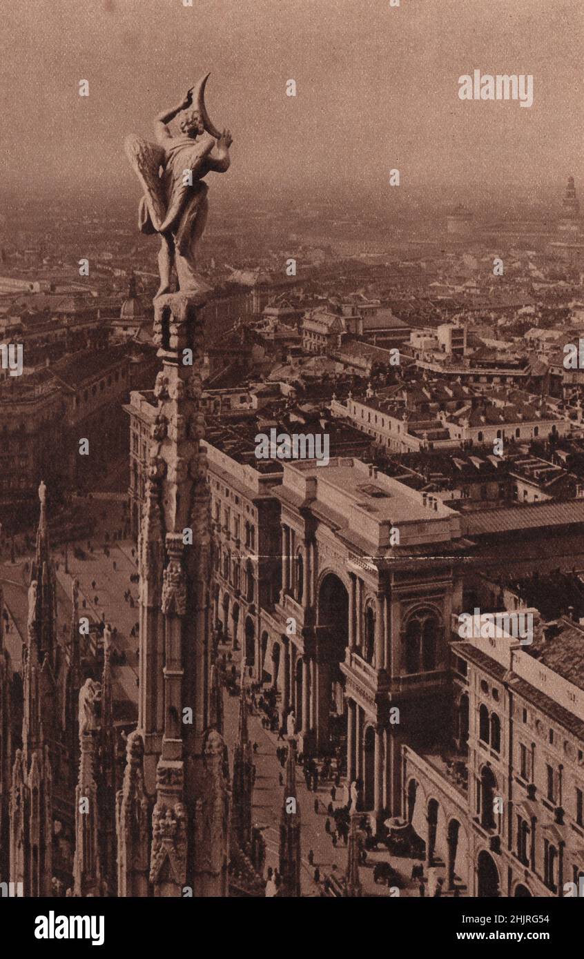 Estatuas de mármol sobre delgados pináculos, encaramadas vertiginosamente por encima de la Galería Victor Emmanuel, adornan la Catedral de Milán. Italia (1923) Foto de stock
