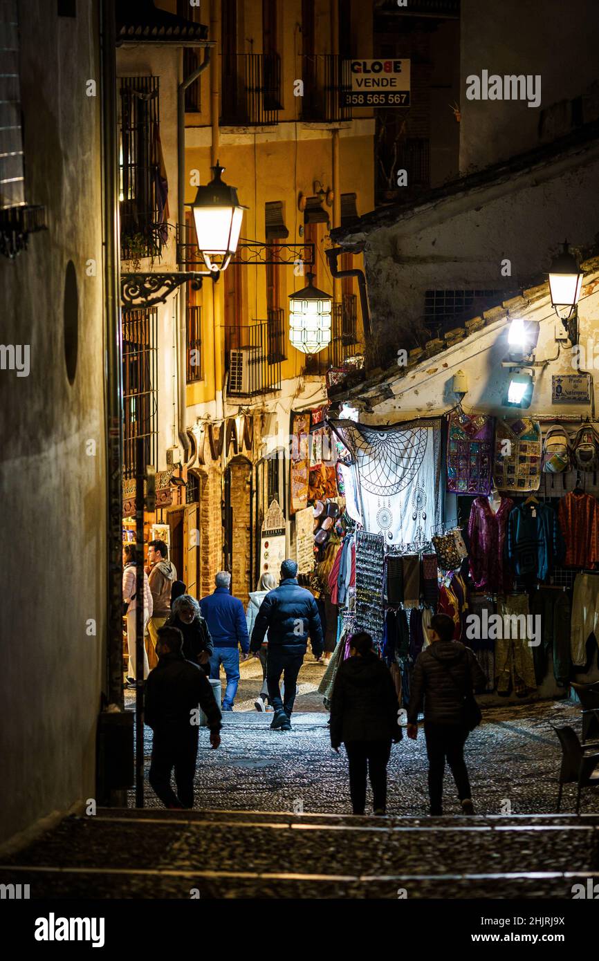 Granada, España - 11 2021 de noviembre: Los turistas y la gente local caminan por la estrecha calle del casco antiguo medieval de Granada en Andalucía, en el sur de Sp Foto de stock