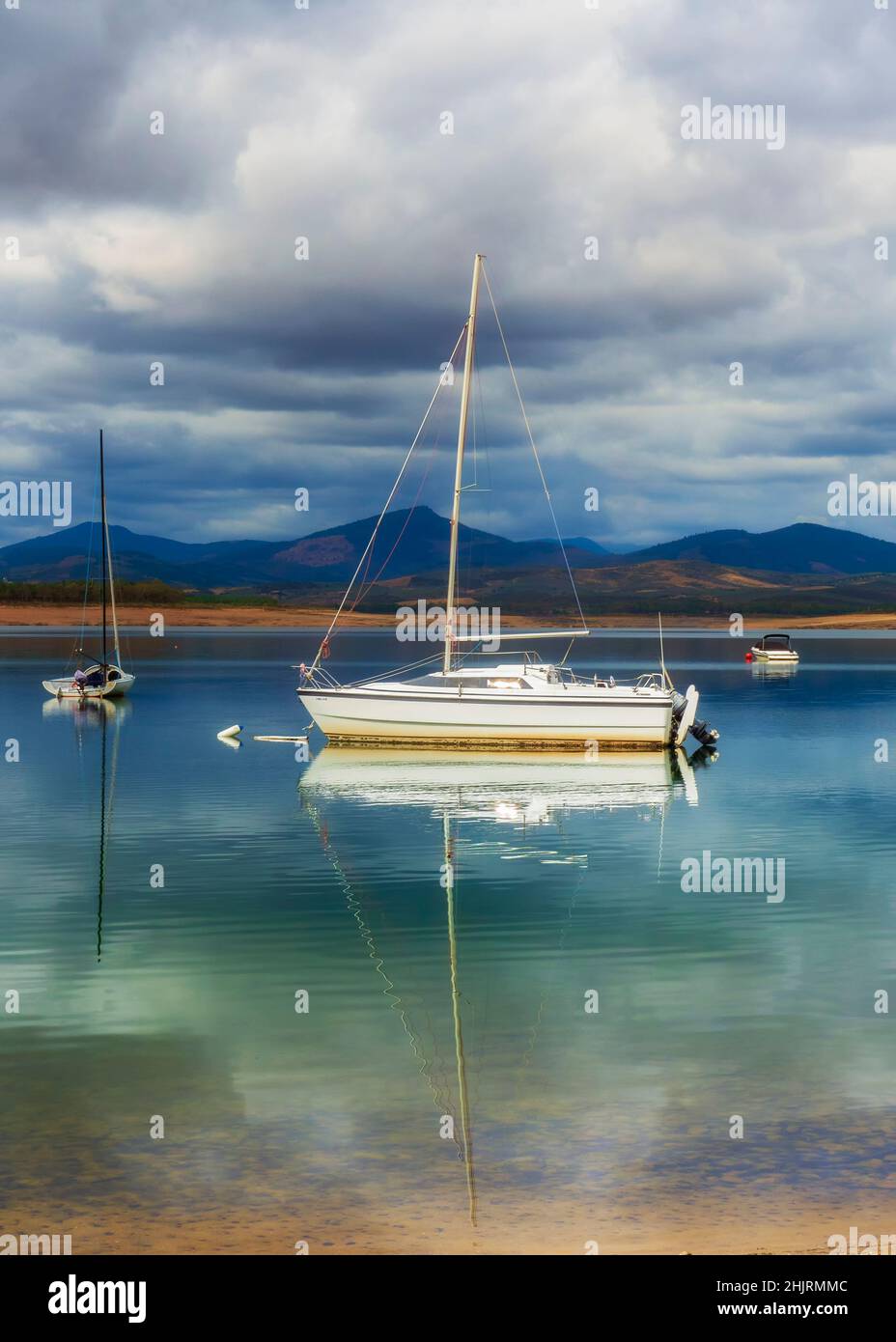 Barco de placer que se refleja en el agua del lago Foto de stock