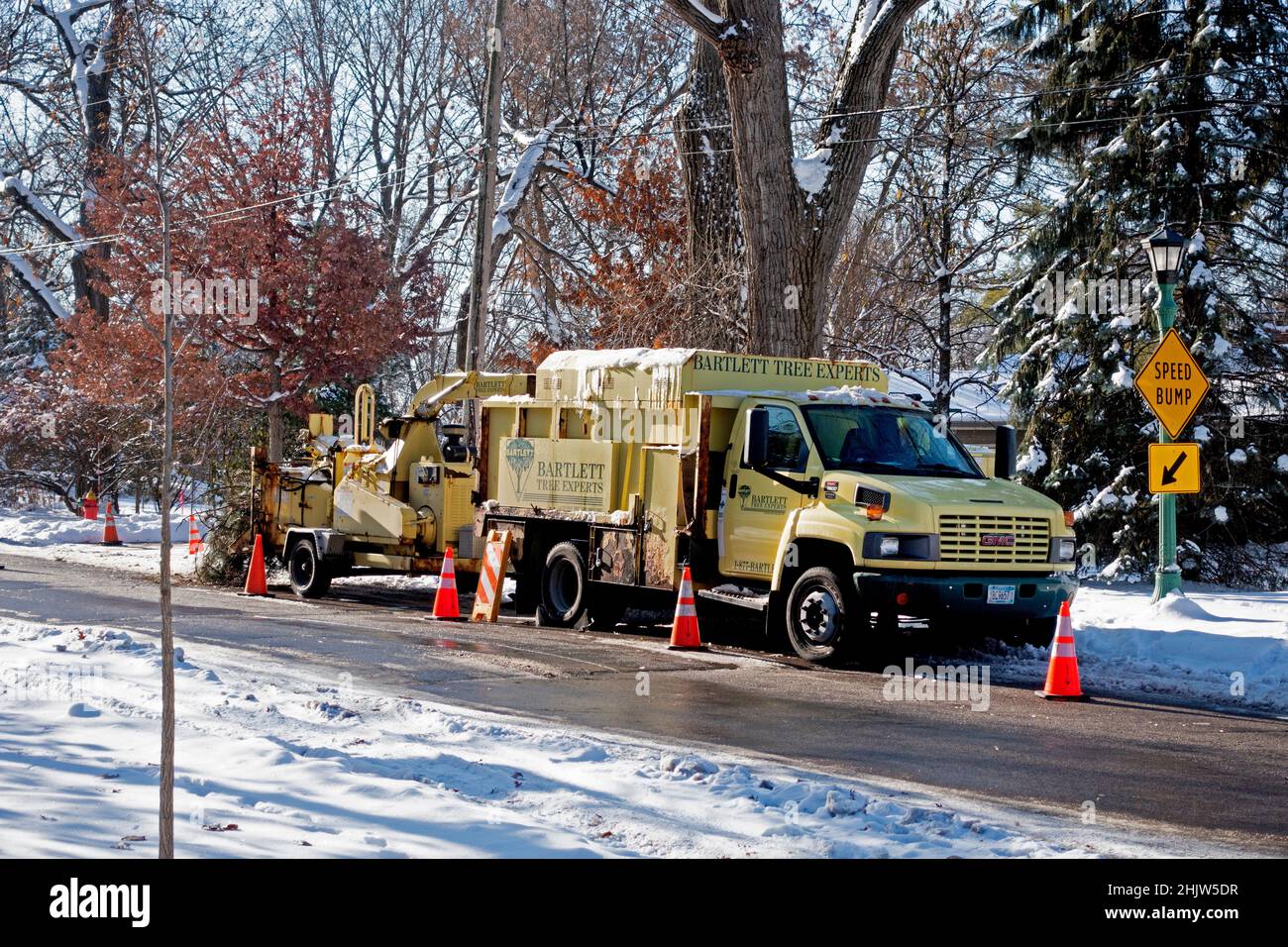 Camión para cortar árboles de invierno rodeados de conos de advertencia naranjas para mayor seguridad. St Paul Minnesota MN EE.UU Foto de stock