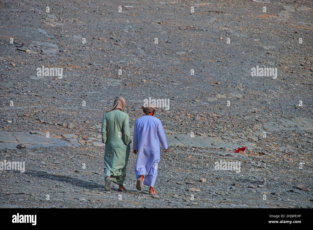 Dos hombres con ropa árabe caminando en el desierto Foto de stock