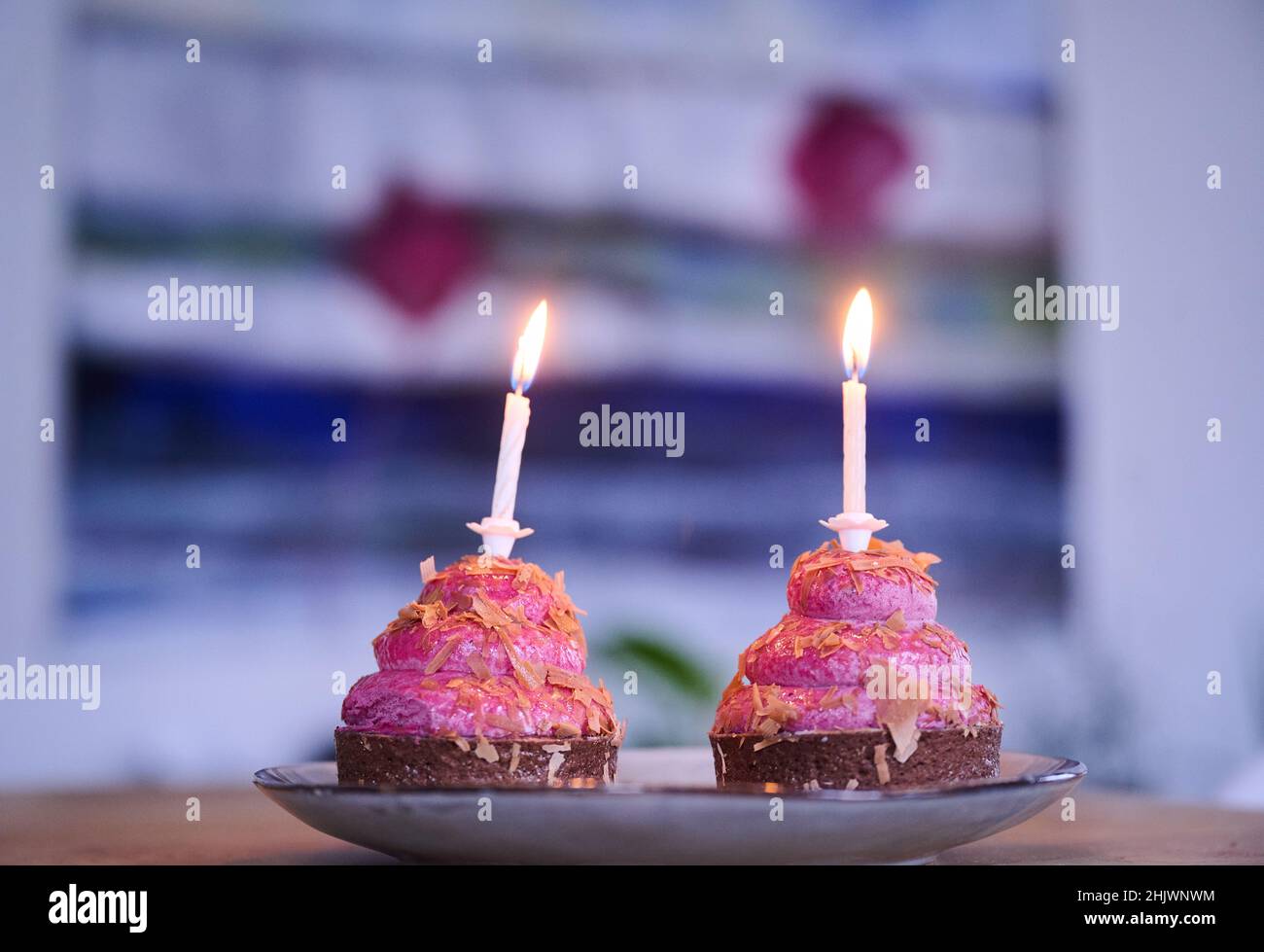 Berlín, Alemania. 12th de Ene de 2022. ILUSTRACIÓN - Dos cupcakes con velas  encendidas están de pie sobre una mesa. (Escena posada) El '2': Símbolo para  los opuestos, pero también para el