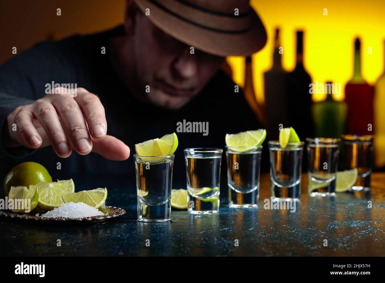 El hombre en el sombrero está bebiendo tequila con rodajas de sal y cal.  Enfoque selectivo Fotografía de stock - Alamy