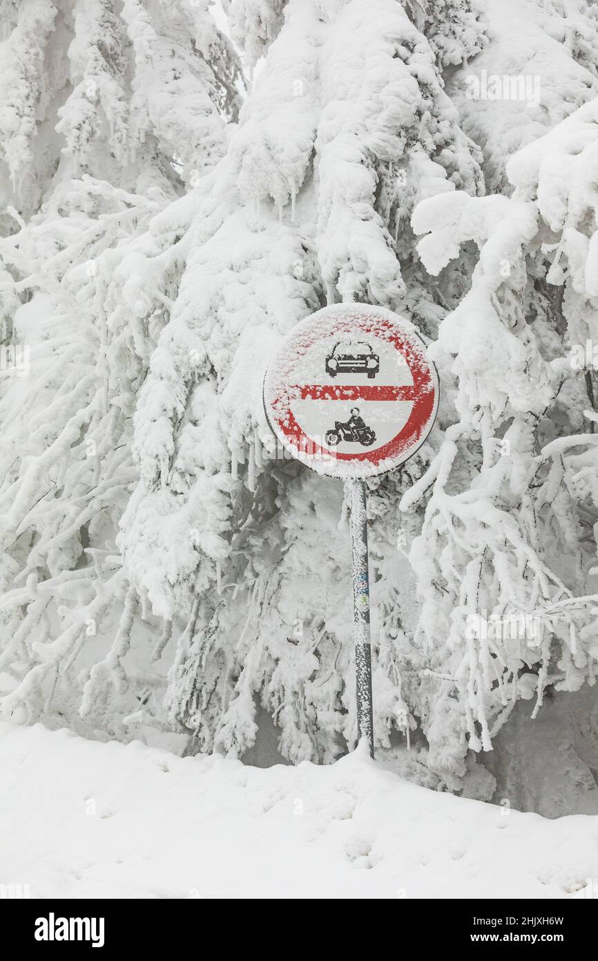 Señal de carretera sin entrada cubierta de nieve y hielo. Paisaje nevado de invierno y señal de carretera Foto de stock