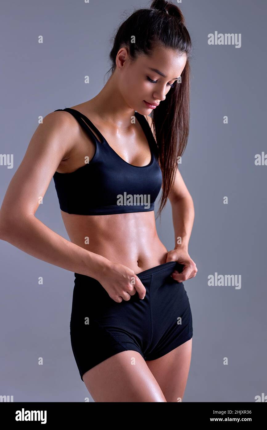 hermosa mujer mostrando cuerpo perfecto y deportes estómago. Concepto de  estilo de vida saludable y de alimentación. Mujer deportiva de fitness que  muestra un cuerpo bien entrenado Fotografía de stock - Alamy