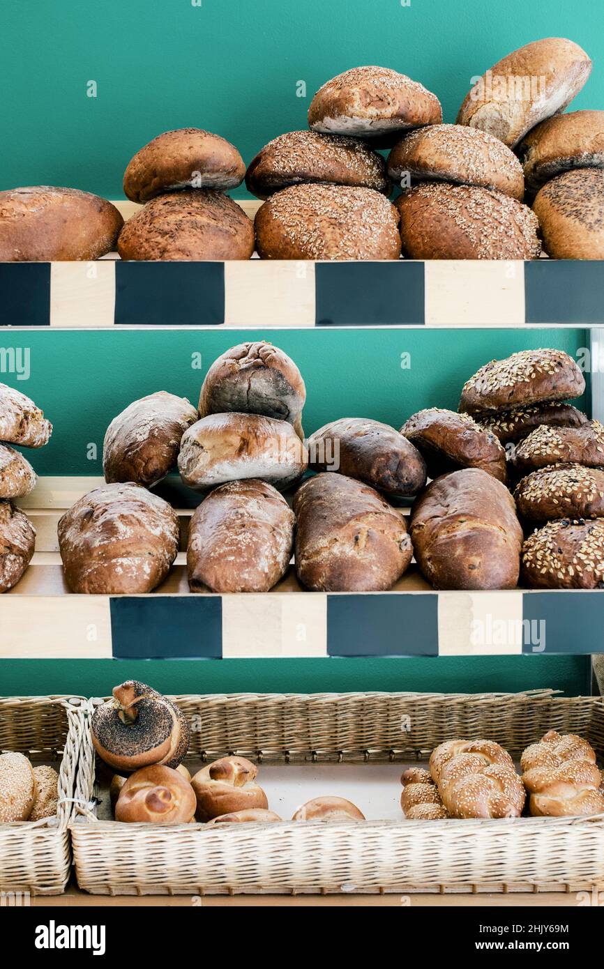 Pan y baguette dispuestos en el estante en la panadería Foto de stock