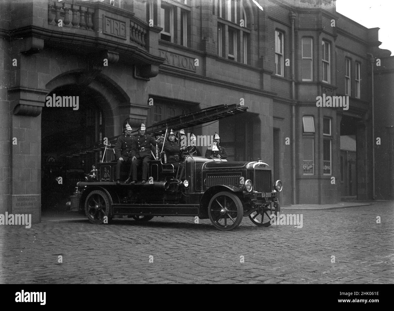 Bombero en el motor de bomberos de Leyland saliendo de la estación de bomberos de Salford en 1920 Foto de stock