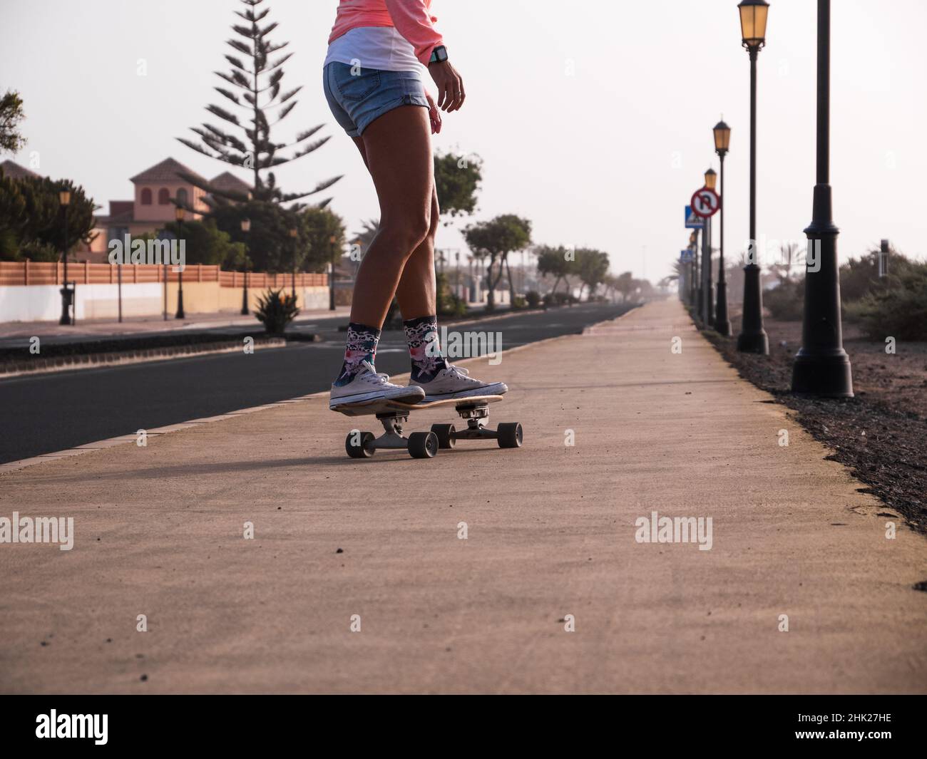 Unas piernas de mujer patinadora irreconocibles descendiendo en el skateboard de surfskate carver Foto de stock