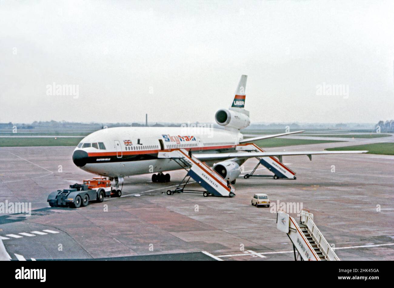 Un “Skytrain” de Laker Airways McDonnell Douglas DC-10 nombrado “Eastern Belle” en el aeropuerto de Manchester, Inglaterra, Reino Unido en 1973. Laker Airways fue una aerolínea británica privada fundada por Sir Freddie Laker en 1966. Laker voló el primer vuelo transatlántico «ABC» (carta de reserva anticipada) del mundo en abril de 1973 desde Manchester a Toronto utilizando un «Skytrain» DC-10. Fue pionero en la era de la tarifa baja sin florituras y fue inicialmente exitoso. Otras aerolíneas más grandes bajaron sus tarifas para competir y Laker entró en quiebra en 1982. Esta imagen proviene de una antigua transparencia de color amateur, una fotografía vintage de 1970s. Foto de stock