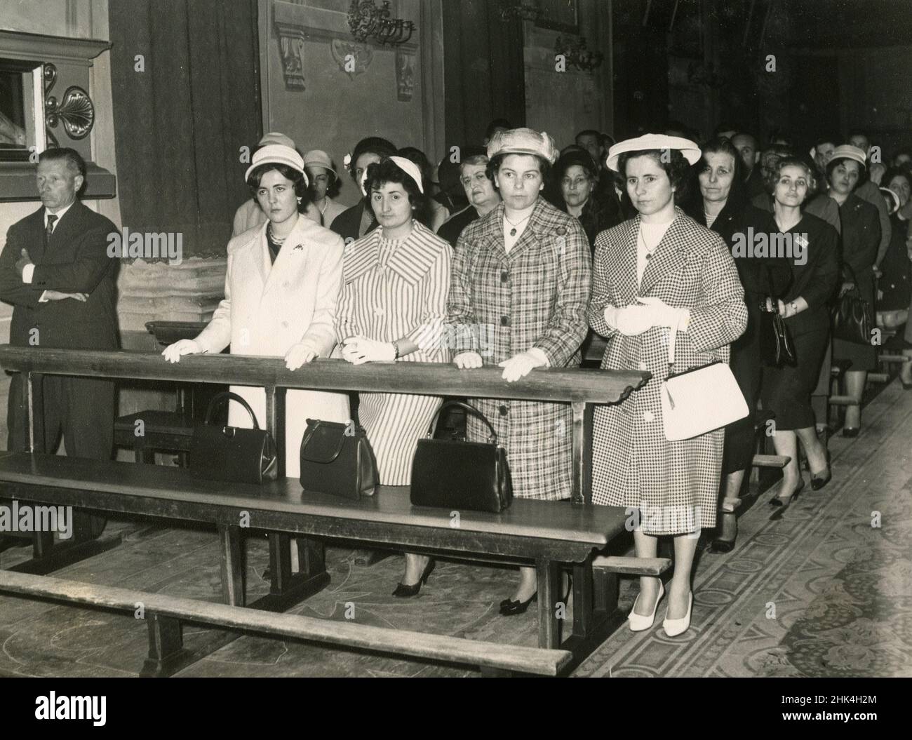 Boda en Italia durante el 1950s: Amigos y familiares de la pareja en los bancos de la iglesia Foto de stock
