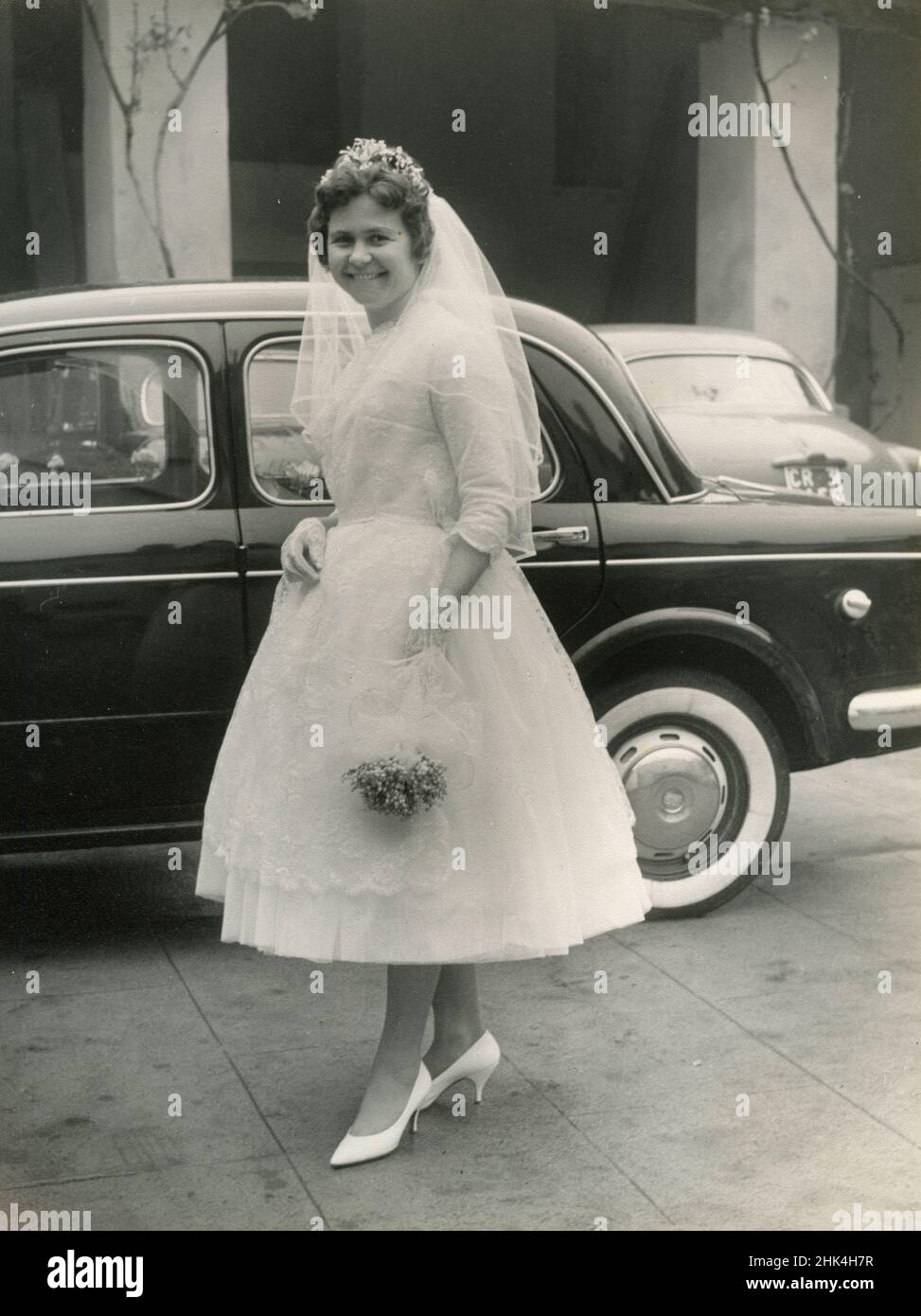 Boda en Italia durante el 1950s: La novia llega a la iglesia con el coche Foto de stock