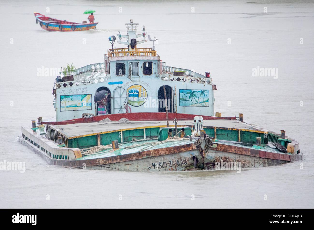 Una barcaza de arena muy cargada en su camino para descargar arena a las fábricas de cemento cerca del puente Kanchon en las afueras de Dhaka en Bangladesh. Los ríos son los principales minerales de transporte en el país del delta. Foto de stock