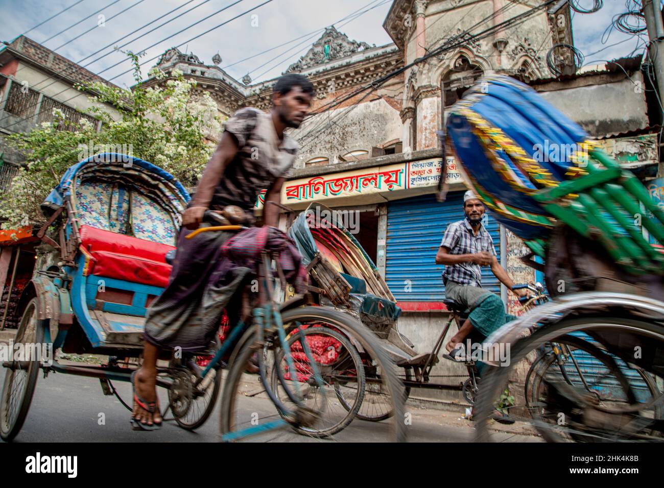 Los pullers de rickshaw en las calles de Puran Dhaka - Old Dhaka en Bangladesh. Las rickshaws son triciclos accionados por pedal, pero se solía tirar a mano, por lo tanto 'rickshaw extractor'. Hoy en día muchas de las sierras de rickshaws se convierten incluso para ser alimentado por motor eléctrico. Foto de stock