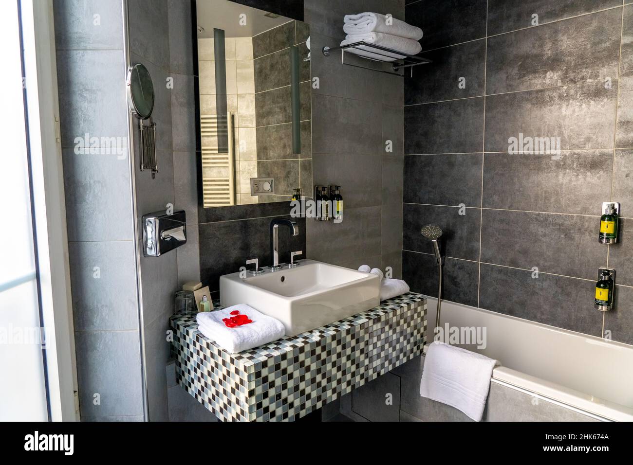 Paris, FRANCIA - 11.11.2021 - Cuarto de baño de lujo con ducha y decoración  en piedra blanca y negra. Lavabo blanco, inodoro y muebles. Primer plano  del producto de higiene del hotel