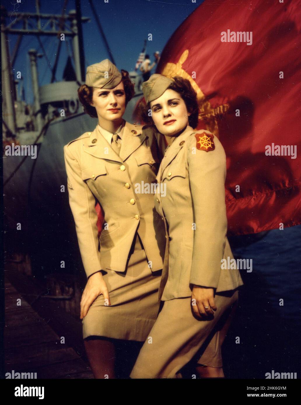 WWII - La bandera del Cuerpo de Transporte es un fondo apropiado para Cpl. Beth Haddow y PFC. Dorothy Hamilton, WACS en el Cuerpo de Transporte en el Puerto de Embarque de Hampton Roads, Newport News, Virginia Foto de stock