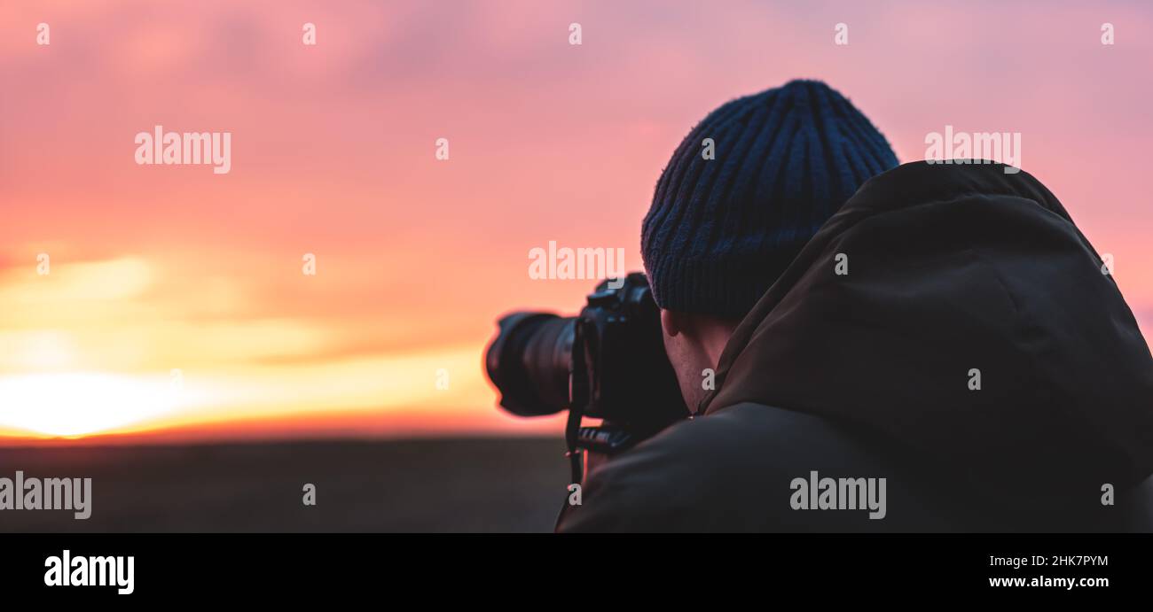 El fotógrafo en la puesta del sol que captura paisaje de la puesta del sol. Fotografía de la naturaleza del viaje. Foto de stock