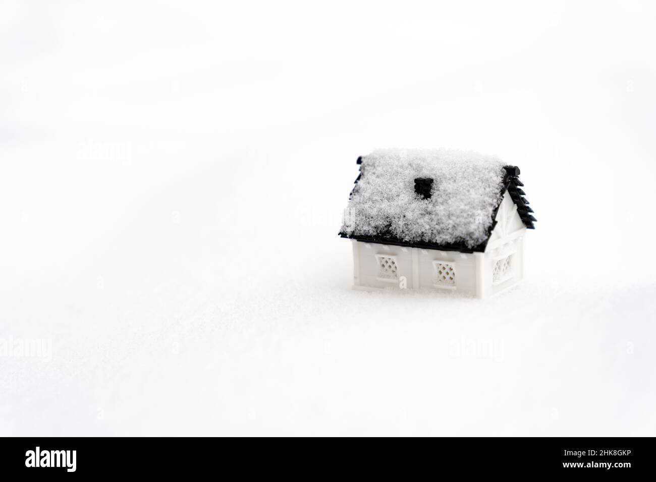 Casa modelo 3D sobre fondo natural de nieve para la temporada de invierno Foto de stock