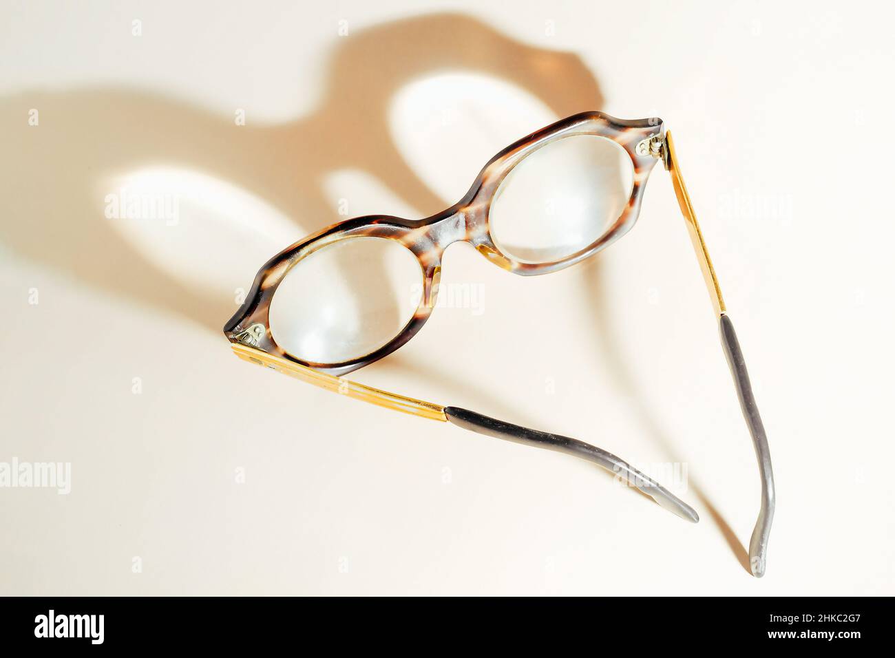 Las gafas para las personas mayores se encuentran sobre fondo beige y  sombra de yeso. Vista desde arriba. Tema del deterioro de la visión con la  edad. Miopía senil. No gafas de