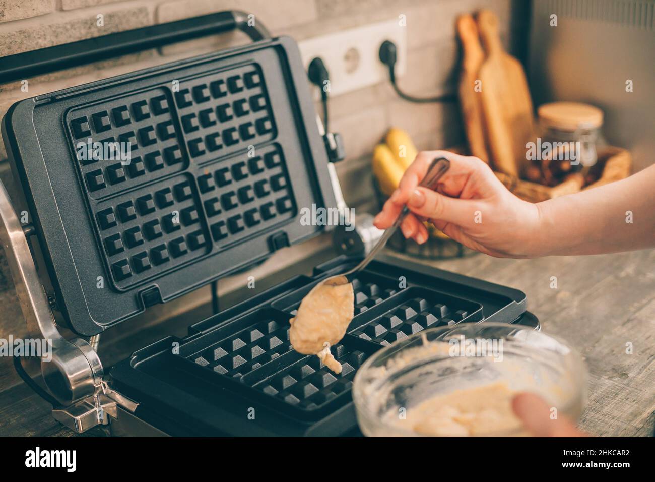https://c8.alamy.com/compes/2hkcar2/mujer-joven-preparando-gofres-belgas-en-la-cocina-proceso-de-coccion-2hkcar2.jpg