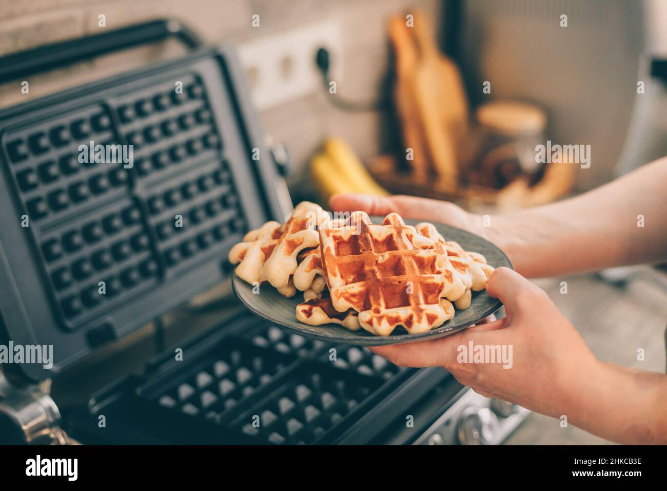 https://c8.alamy.com/compes/2hkcb3e/mujer-joven-sosteniendo-en-plato-de-manos-con-gofres-belgas-2hkcb3e.jpg