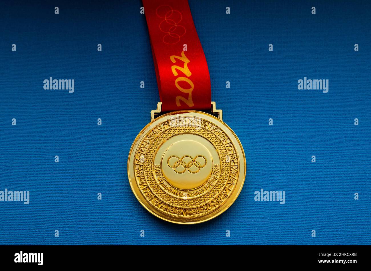 27 de enero de 2022, Beijing, China. XXIV medalla de oro de los Juegos Olímpicos de Invierno sobre fondo azul. Foto de stock