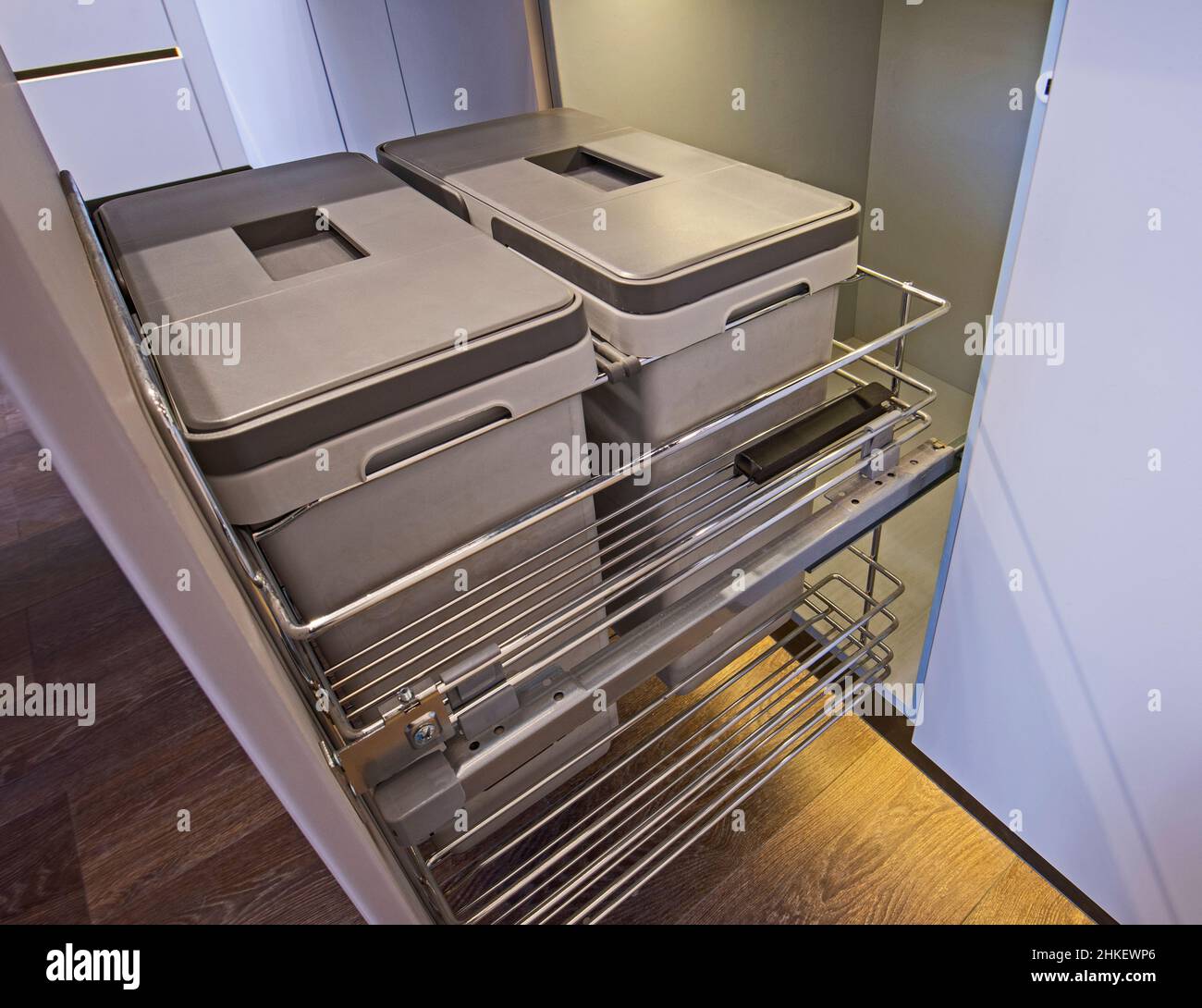 Decoración de diseño interior de la cocina en apartamento de lujo mostrando closeup detalle de armario deslizante con basureros Foto de stock