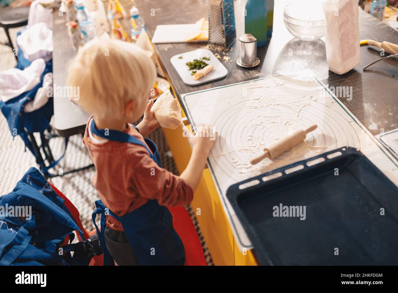 Clase de taller de cocción para niños de la escuela. Lindo niño en delantal  de cocina aprendizaje juguetón para hornear pasteles que se divierten. Niños  jugando con flo de Trigo Fotografía de