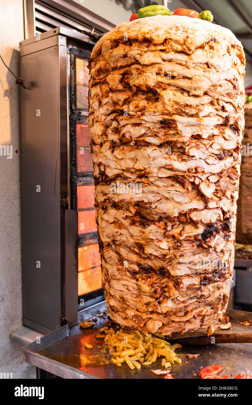 Carne de pollo a la parrilla en una rotiserie vertical utilizada en la comida tradicional turca de la calle Doner Kebab (Shawarma o Gyros en otras culturas) en Estambul, T. Foto de stock