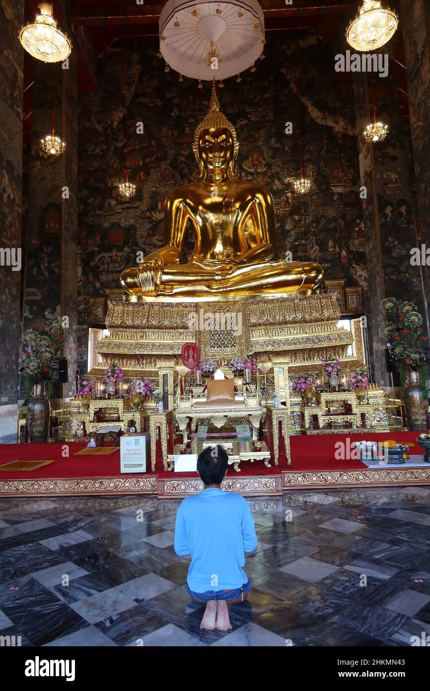 Hombre en oración en Wat Suthat Thepwararam, templo budista con buda dorado, Wat Suthat, Bangkok, Tailandia. Foto de stock