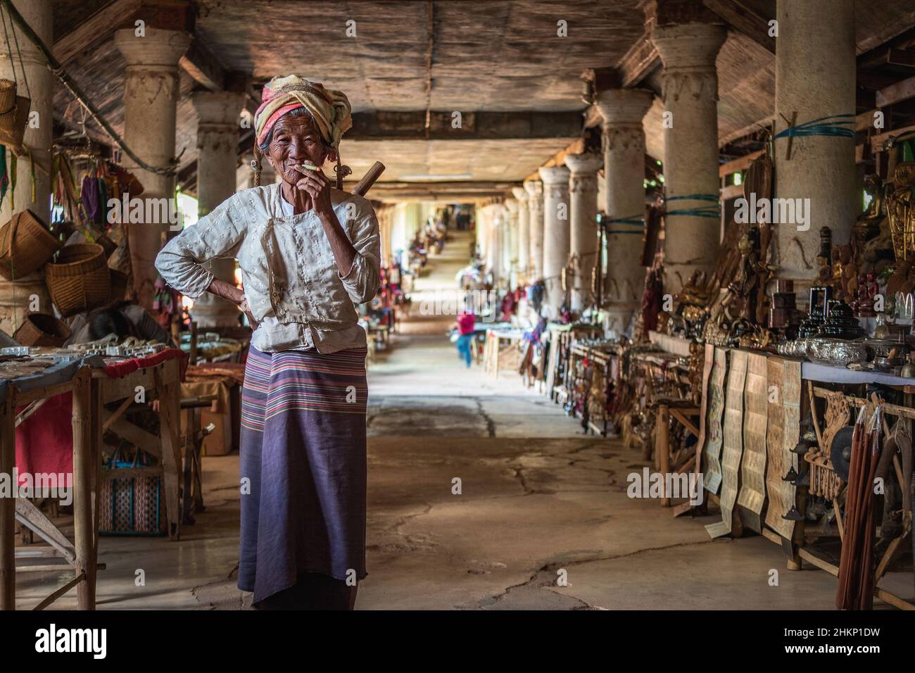 Anciana birmana que fuma un cigarro en el mercado de artesanías tradicionales en la aldea de Indein, estado de Shan, Myanmar (Birmania). Foto de stock