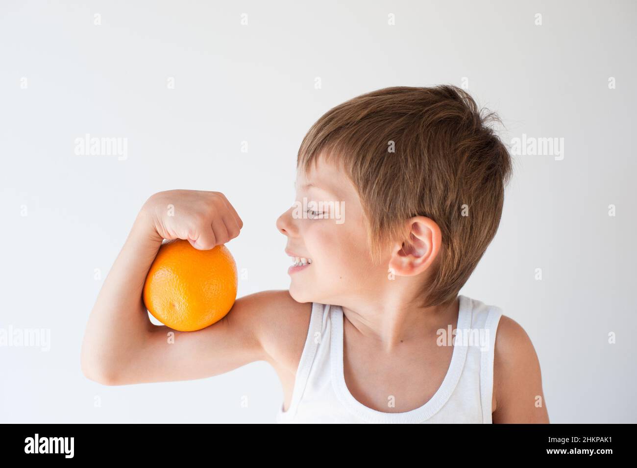 un niño pequeño sano quiere comer naranja Foto de stock