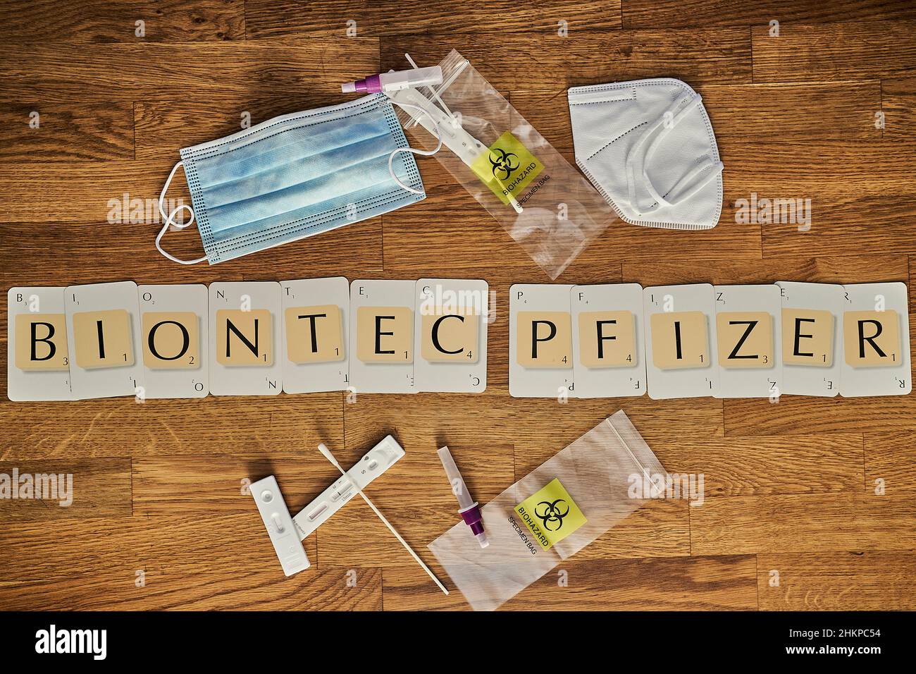 Cartas de Scrabble deletreando la corona covid 19 Palabras relacionadas con la pandemia Biontec Pfizer Foto de stock