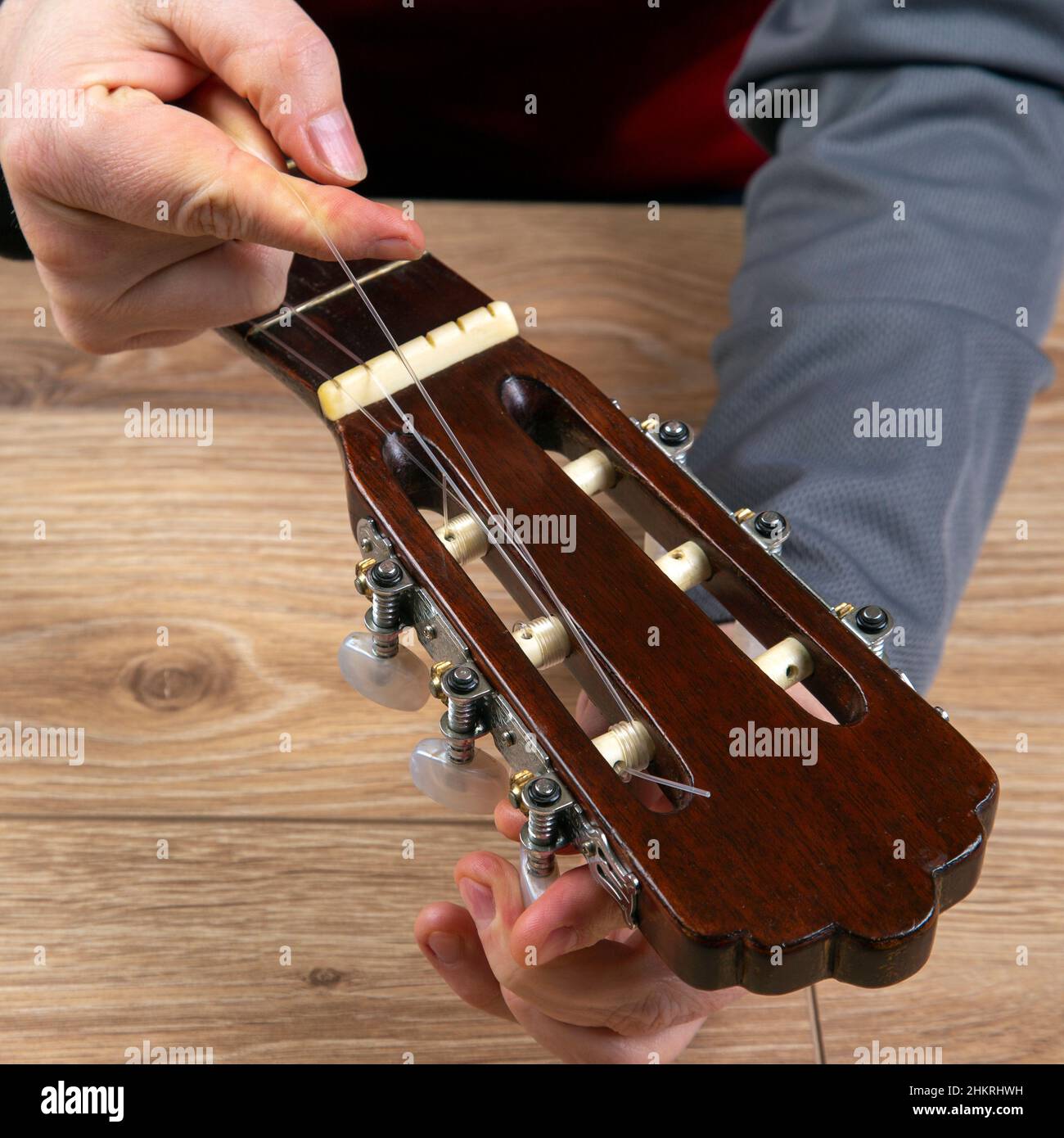 Cambio de cuerdas de nailon en una guitarra clásica de seis cuerdas.  Instrucción para músico Fotografía de stock - Alamy