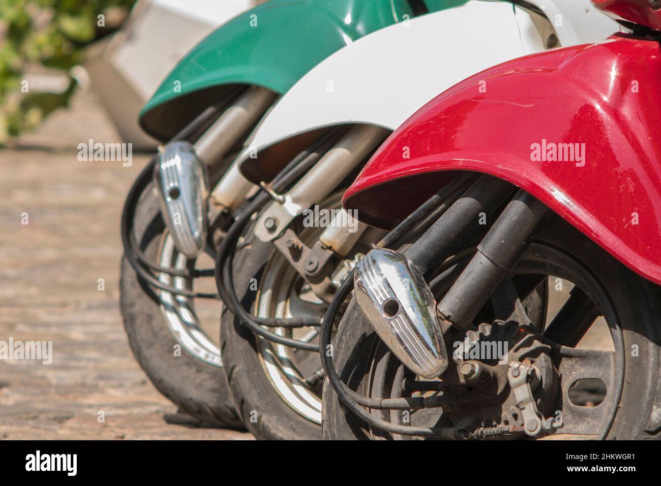 Tres ciclomotores pintados en colores de la bandera italiana en el casco antiguo Foto de stock