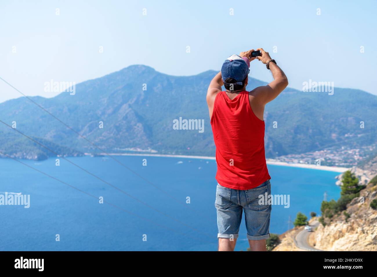 Joven atleta tomando fotos y video del mar de vacaciones con una cámara de acción. Foto de stock