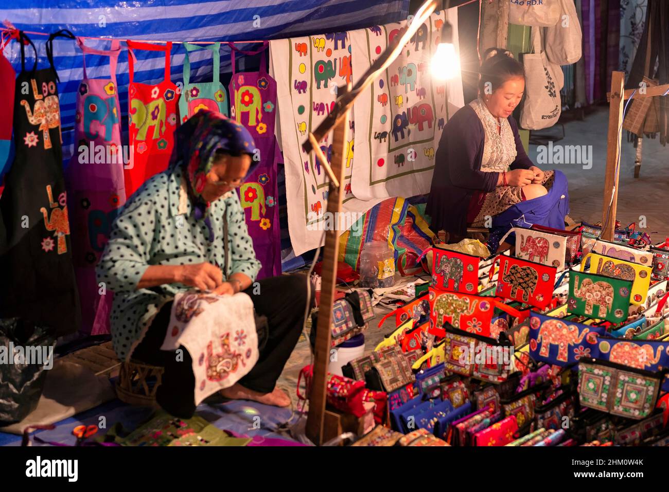 Mujeres que venden productos hechos a mano en el mercado nocturno en Luang Prabang, Laos Foto de stock